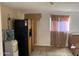 Kitchen area with refrigerator, window, and doorway open to another area of the house at 3946 W Holly St, Phoenix, AZ 85009