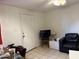 Living room area with television, chair and adjacent entrance door at 3946 W Holly St, Phoenix, AZ 85009