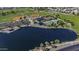 Scenic aerial view of the community lake, baseball fields, tennis courts, and lush green spaces for recreation and leisure at 41581 W Somerset Dr, Maricopa, AZ 85138