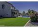 Lush green lawn and pool area with a patio extending from the house at 41581 W Somerset Dr, Maricopa, AZ 85138