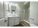 Well-lit bathroom featuring a sleek vanity with storage and a glass-enclosed shower at 41581 W Somerset Dr, Maricopa, AZ 85138