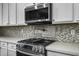 Close up of modern stainless oven and backsplash at 41581 W Somerset Dr, Maricopa, AZ 85138