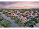 Expansive aerial view of a residential community with tile roofs, mature landscaping, and mountain views at sunset at 4208 E Hamblin Dr, Phoenix, AZ 85050