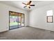 Carpeted main bedroom with a ceiling fan, and sliding door to the outdoor patio at 4208 E Hamblin Dr, Phoenix, AZ 85050