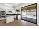 Bright kitchen with stainless steel appliances, granite counters, and sliding glass door to backyard at 4208 E Hamblin Dr, Phoenix, AZ 85050