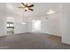 Open-concept living room with carpeted floors, and arched doorways connecting to the kitchen and other living areas at 4208 E Hamblin Dr, Phoenix, AZ 85050