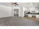 Spacious living room flowing into the kitchen, featuring neutral carpet, and arched doorways for an open concept feel at 4208 E Hamblin Dr, Phoenix, AZ 85050