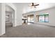 Open concept living area with neutral colored carpet and large windows overlooking the backyard pool at 4208 E Hamblin Dr, Phoenix, AZ 85050