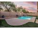 Backyard pool with elegant brick waterfall feature and sunset at 4208 E Hamblin Dr, Phoenix, AZ 85050