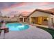 Backyard pool at sunset, showing tiled roof, patio, and lighting at 4208 E Hamblin Dr, Phoenix, AZ 85050