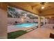 Backyard pool with lush landscaping, lighting, and covered patio at 4208 E Hamblin Dr, Phoenix, AZ 85050