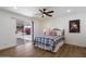 Cozy bedroom with wood-style flooring, ceiling fan, and sliding glass doors to the backyard at 427 S 80Th Way, Mesa, AZ 85208