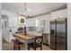 Bright kitchen features white cabinetry, stainless steel appliances, an island with seating, and a modern chandelier at 427 S 80Th Way, Mesa, AZ 85208