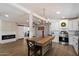 Modern kitchen featuring an island with seating, stainless steel appliances, white cabinets, and a sliding barn door at 427 S 80Th Way, Mesa, AZ 85208