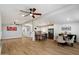Open-concept living area with wood-look floors, ceiling fans, and a view into the bright kitchen at 427 S 80Th Way, Mesa, AZ 85208