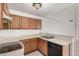 A look at the kitchen with wood cabinets, white countertops and a black dishwasher at 4406 E Carter Dr, Phoenix, AZ 85042