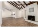 Open living room with beams, a fireplace, and wood-look floors that flow into the kitchen at 4722 W Via Cynthia --, Glendale, AZ 85301
