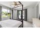 Light-filled bedroom with a four-poster bed, ceiling fan, and large windows overlooking the backyard at 5051 E Lafayette Blvd, Phoenix, AZ 85018