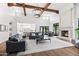 Open-concept living room with high ceilings, exposed beams, and a cozy fireplace at 5051 E Lafayette Blvd, Phoenix, AZ 85018