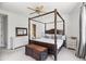 Spacious primary bedroom with a four-poster bed, neutral decor, and a ceiling fan for added comfort at 5051 E Lafayette Blvd, Phoenix, AZ 85018