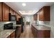 Galley kitchen featuring stainless steel appliances, granite countertops, wood cabinets, and ample storage at 520 S Greenfield Rd # 7, Mesa, AZ 85206