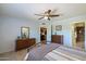 Comfortable main bedroom with ceiling fan, tiled floor, and view to the kitchen and main bathroom at 520 S Greenfield Rd # 7, Mesa, AZ 85206
