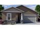 Inviting single-story home showcasing a two-car garage and neutral stucco facade accented by decorative stone trim at 5722 E Iris Dr, Florence, AZ 85132