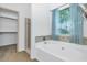 Bathroom with a soaking tub, glass-enclosed shower, and window with natural lighting at 5733 E Jaeger St, Mesa, AZ 85205