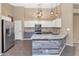 Modern kitchen with stainless steel appliances, white cabinets, and granite countertops at 5733 E Jaeger St, Mesa, AZ 85205