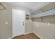 Neutral laundry room with brown tile floor, white door, and shelving with decorative paper at 5733 E Jaeger St, Mesa, AZ 85205