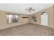 Bright and spacious living room featuring neutral carpet, ceiling fan, and arched windows at 5733 E Jaeger St, Mesa, AZ 85205