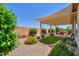 Inviting backyard with gravel, patio cover, artificial turf, and lush landscaping offers a relaxing outdoor space at 60 S Agua Fria Ln, Casa Grande, AZ 85194