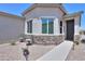 Charming home featuring stone accents, desert landscaping, and a cozy seating area at 60 S Agua Fria Ln, Casa Grande, AZ 85194