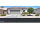 Charming single-story home with a two-car garage, desert landscaping, and shade tree at 60 S Agua Fria Ln, Casa Grande, AZ 85194