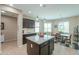 Open kitchen with large island, granite counters, dark cabinets and an adjacent dining area at 60 S Agua Fria Ln, Casa Grande, AZ 85194