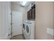 Functional laundry room with appliances, storage cabinets, and tile flooring at 60 S Agua Fria Ln, Casa Grande, AZ 85194
