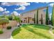 Expansive backyard with lush lawn, mature trees, a covered patio, and a refreshing pool at 6961 W Honeysuckle Dr, Peoria, AZ 85383