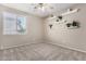 Bright bedroom with a ceiling fan, carpet, one window, and shelving at 6961 W Honeysuckle Dr, Peoria, AZ 85383