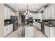 Well-lit kitchen featuring white cabinets, granite countertops, stainless steel appliances, and a kitchen island at 6961 W Honeysuckle Dr, Peoria, AZ 85383