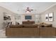 A staged living room with a plush brown sofa, modern art, and a ceiling fan for a relaxing atmosphere at 6961 W Honeysuckle Dr, Peoria, AZ 85383