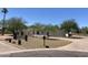 Beautiful single-story home with desert landscaping, mature trees, circular driveway, and an American flag in the yard at 7044 E Ann Way, Scottsdale, AZ 85254