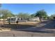 A single-story home featuring desert landscaping, mature trees, and a low privacy wall at 7044 E Ann Way, Scottsdale, AZ 85254