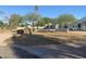 A single-story home featuring desert landscaping, mature trees, and a low privacy wall at 7044 E Ann Way, Scottsdale, AZ 85254
