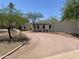 Elegant single-story home with well-maintained desert landscaping, mature trees, and a circular driveway leading to the entrance at 7044 E Ann Way, Scottsdale, AZ 85254