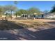 Charming single-story home featuring desert landscaping, mature trees, and a low privacy wall at 7044 E Ann Way, Scottsdale, AZ 85254