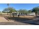 Charming single-story home featuring desert landscaping, mature trees, and a low privacy wall at 7044 E Ann Way, Scottsdale, AZ 85254