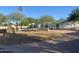 A single-story home featuring desert landscaping, mature trees, and a low privacy wall at 7044 E Ann Way, Scottsdale, AZ 85254