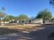 Charming single-story home featuring desert landscaping, mature trees, and a low privacy wall at 7044 E Ann Way, Scottsdale, AZ 85254