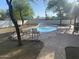 Enjoy this sparkling pool with a rock border, a lounge area, and beautiful trees at 7044 E Ann Way, Scottsdale, AZ 85254