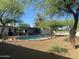 Inviting backyard pool featuring diving board, rock surround, and lush landscaping for relaxation and entertainment at 7044 E Ann Way, Scottsdale, AZ 85254